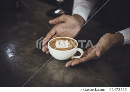Male Barista preparing coffee for customer in coffee shop 61472813
