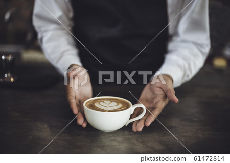 Male Barista preparing coffee for customer in coffee shop 61472814