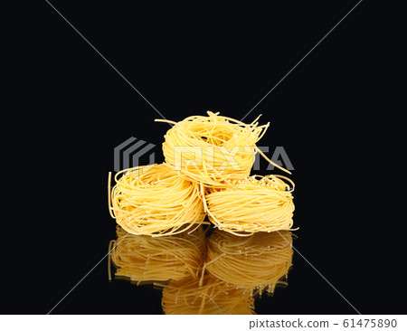 raw dry nest pasta with reflection  on black 61475890