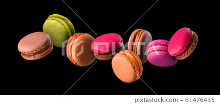 Flying french colorful macaroons on wooden table isolated on black 61476435