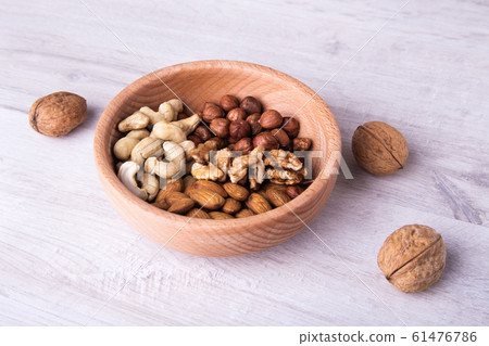wood serving spoon with Assortment nuts on wooden table. Close-up. wood serving spoon with Assortment nuts on wooden table. Close-up. 61476786