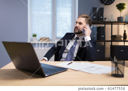 Mature Office Worker Having a Telephone Conversation Mature Office Worker Having a Telephone Conversation 61477558