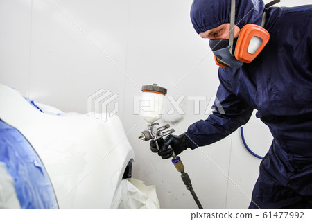 worker with spray gun in spray booth 61477992