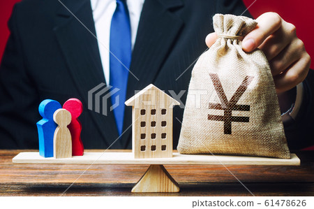 Man puts Yen yuan money bag and house on scales with a family. Mortgage, debt burden. Assistance with housing and financing for young families to stimulate childbirth demographic population growth. Man puts Yen yuan money bag and house on scales with a family. Mortgage, debt burden. Assistance with housing and financing for young families to stimulate childbirth demographic population growth. 61478626