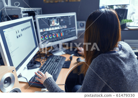 The Brunette Is Carefully At The Monitor Of Her Computer And Working In A Video Processing Program The Brunette Is Carefully At The Monitor Of Her Computer And Working In A Video Processing Program 61479330