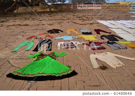 Laundry hanged on brick slopes of Ghats along the Ganges River, Varanasi, India's World Heritage Site 61480648