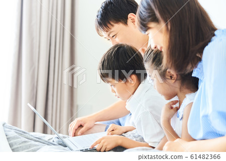 Family watching PC in bedroom bright indoor Family watching PC in bedroom bright indoor 61482366