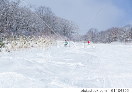 A man sliding on fresh snow beside the slopes A man sliding on fresh snow beside the slopes 61484593