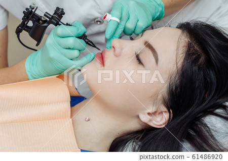 Woman having permanent makeup on lips 61486920