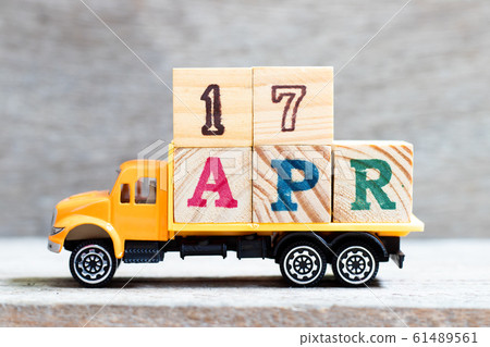 Truck hold letter block in word 17apr on wood background  61489561