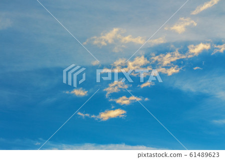 golden clouds on a blue sky at sunset 61489623