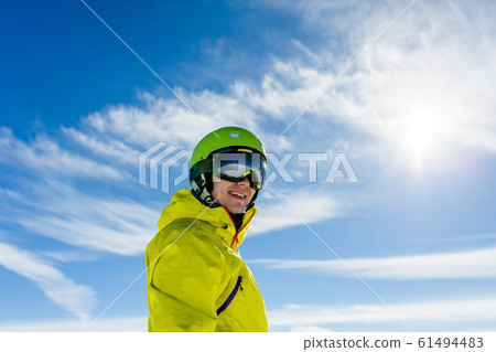 Photo of sporty man wearing mask and helmet against blue sky 61494483