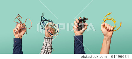 Four hands with some old wires. Concept of electrical waste. 61496684