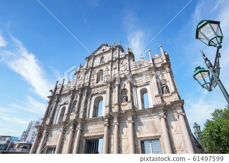 Macao, China - October 16, 2019: Front close up view of The Ruins of Saint Paul's (Ruinas de Sao Paulo) in Macau (Macao) city with blue sky, travel design concept. Macao, China - October 16, 2019: Front close up view of The Ruins of Saint Paul's (Ruinas de Sao Paulo) in Macau (Macao) city with blue sky, travel design concept. 61497599