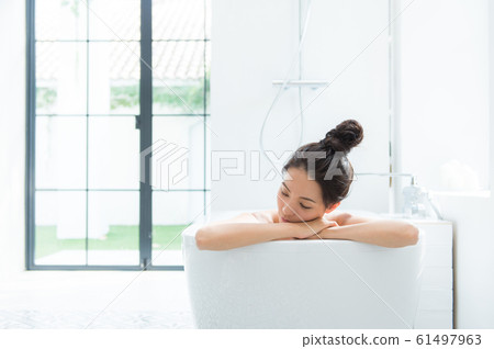 A woman taking a bath 61497963