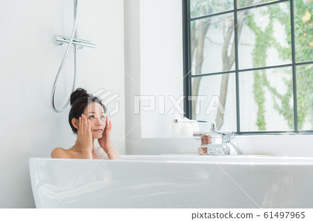 A woman taking a bath 61497965