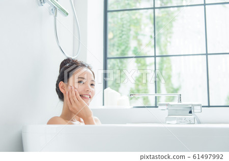 A woman taking a bath A woman taking a bath 61497992