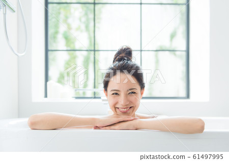 A woman taking a bath A woman taking a bath 61497995