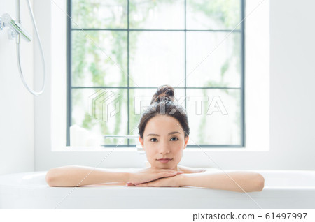 A woman taking a bath A woman taking a bath 61497997