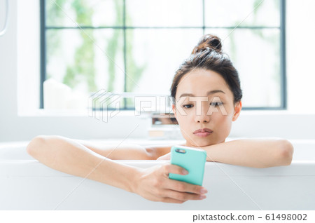 A woman taking a bath 61498002