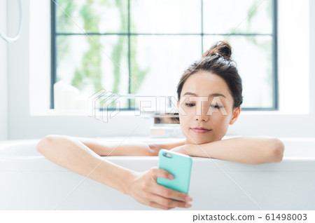 A woman taking a bath 61498003