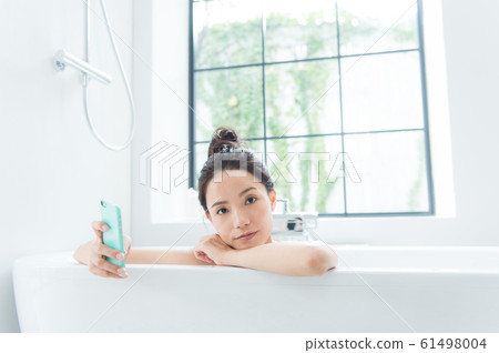 A woman taking a bath 61498004