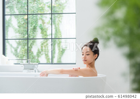 A woman taking a bath A woman taking a bath 61498042