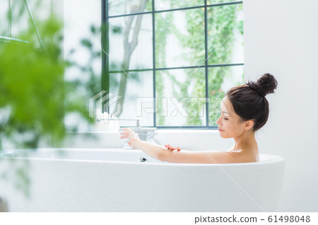A woman taking a bath A woman taking a bath 61498048