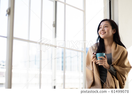 少婦坐與杯子的窗台 61499078