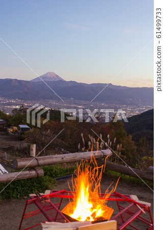 Mt. Fuji and the bonfire that are dyed red in the evening at a campsite in Yamanashi 61499733