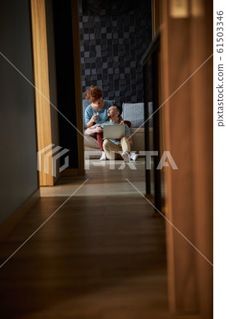 Loving spouces with notebook in living room stock photo 61503346