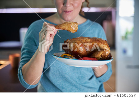 Housewife is tasting cooked chicken stock photo 61503557