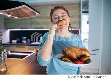 Hungry female biting piece of chicken stock photo 61503559