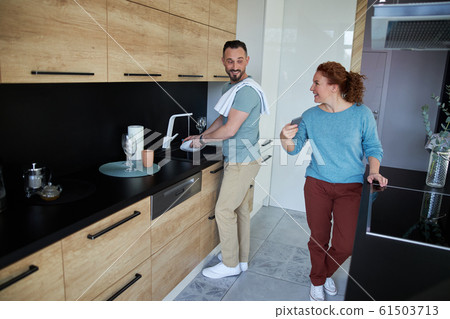 Loving couple doing housework with phone stock photo 61503713