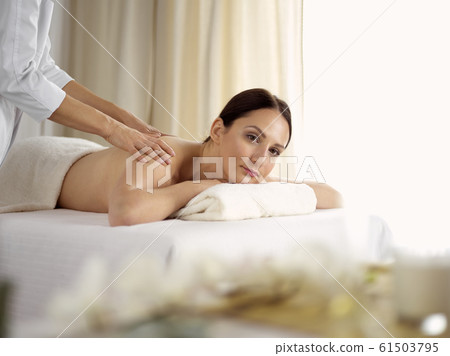 Pretty brunette woman enjoying procedure of back massage in spa salon. Beauty concept Pretty brunette woman enjoying procedure of back massage in spa salon. Beauty concept 61503795
