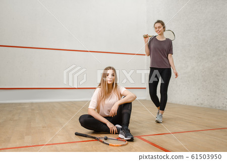 Two female squash players poses on court Two female squash players poses on court 61503950