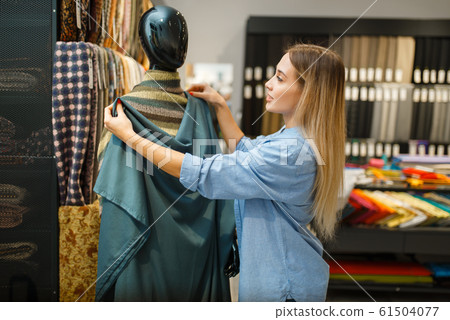 Seamstress with fabric at mannequin, textile store Seamstress with fabric at mannequin, textile store 61504077