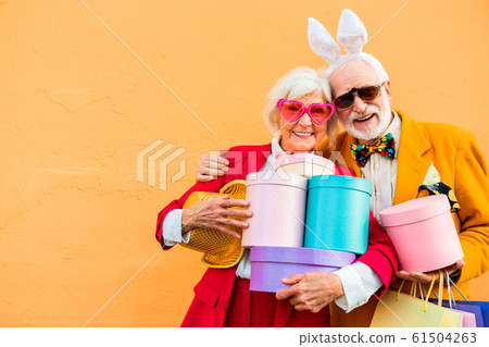 Cheerful elderly man in sunglasses hugging his wife Cheerful elderly man in sunglasses hugging his wife 61504263