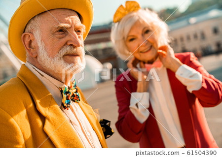 Senior male looking away while walking with wife Senior male looking away while walking with wife 61504390