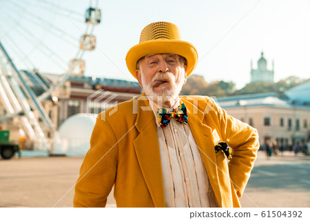 Smiling old man is making feces outdoors Smiling old man is making feces outdoors 61504392