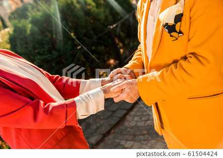 Cropped photo of elderly man holding woman hands 61504424