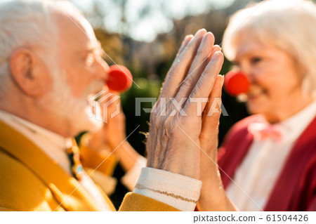 Close up of elderly man and woman holding hands 61504426