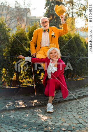 Happy senior woman near her husband in wearing funny accessories Happy senior woman near her husband in wearing funny accessories 61504938