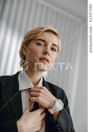 Serious businesswoman posing at camera in studio 61507380