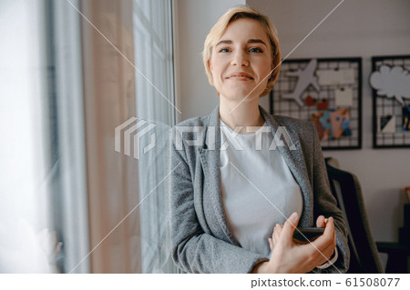 Happy pretty woman is holding mobile phone 61508077