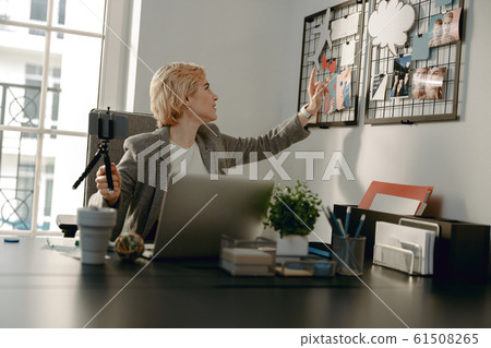 Smiling female blogger making video in the office 61508265