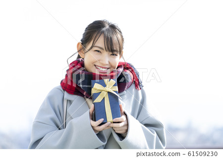 一個有現在的冬季禮物圖像的女人 61509230