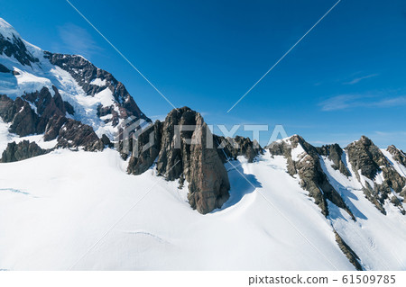 Rock mountain with white snow on ground Rock mountain with white snow on ground 61509785