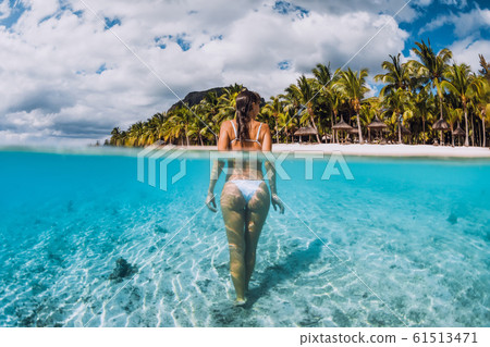 Attractive woman posing in transparent blue ocean. Swimming in blue water at Mauritius Attractive woman posing in transparent blue ocean. Swimming in blue water at Mauritius 61513471