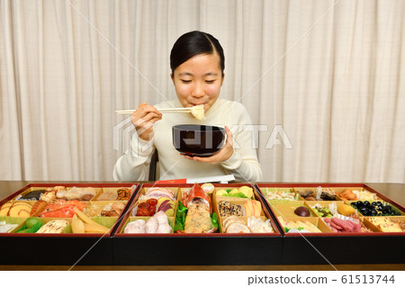 Girl eating New Year dishes (New Year) 61513744